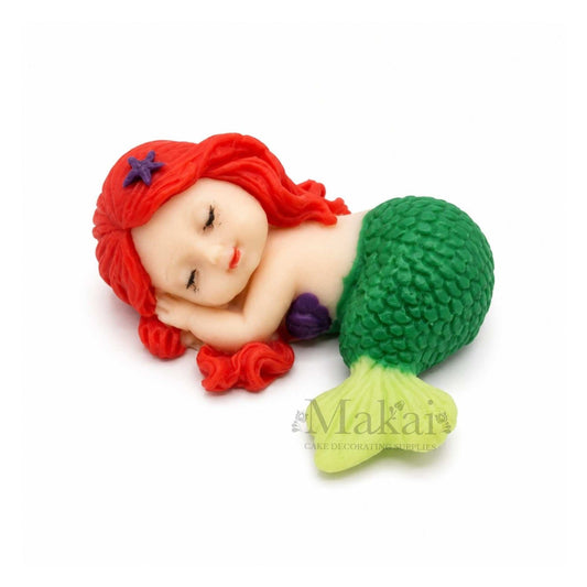 Sleeping mermaid baby edible cake topper with green tail and red hair, ideal for fantasy and ocean-themed cakes.