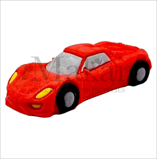 Edible red fondant sports car cake topper with black wheels and yellow headlights.