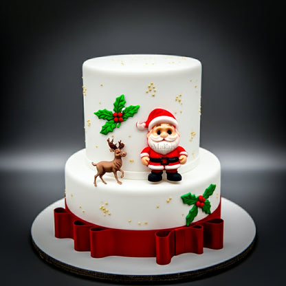 Two-tiered Christmas cake with Santa Claus and reindeer decorations on a dark background by Makai Cake Decorating Supplies