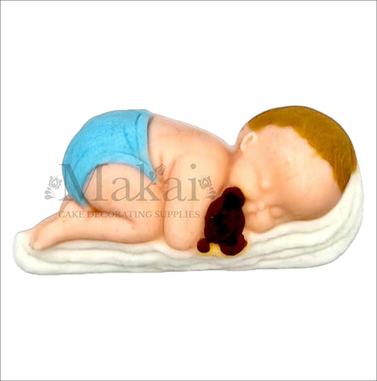 Sleeping baby boy with blue nappy hugging teddy bear cake topper.