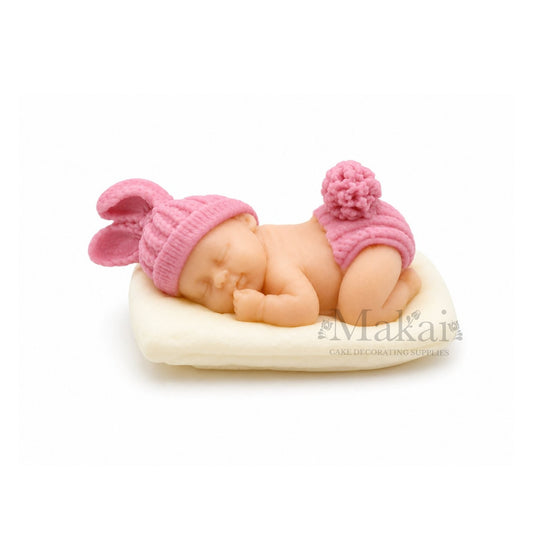 Sleeping baby girl fondant cake topper with pink bunny hat on white cushion