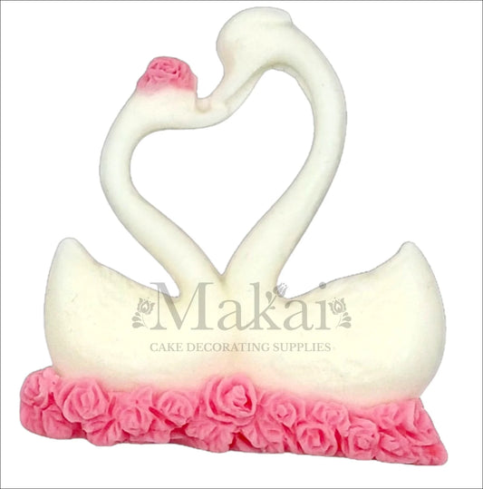 Pair of white swans forming heart shape on pink rose base cake topper.