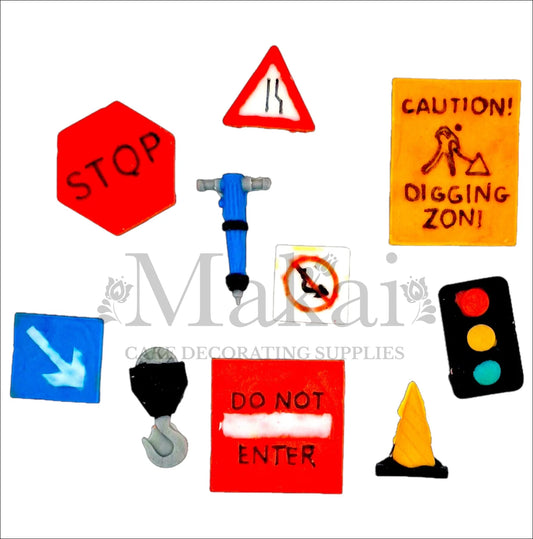 Edible cake toppers of traffic lights, road signs, construction cone and jackhammer in bright colours.