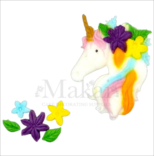 Unicorn head cake topper with rainbow mane and colourful flowers.